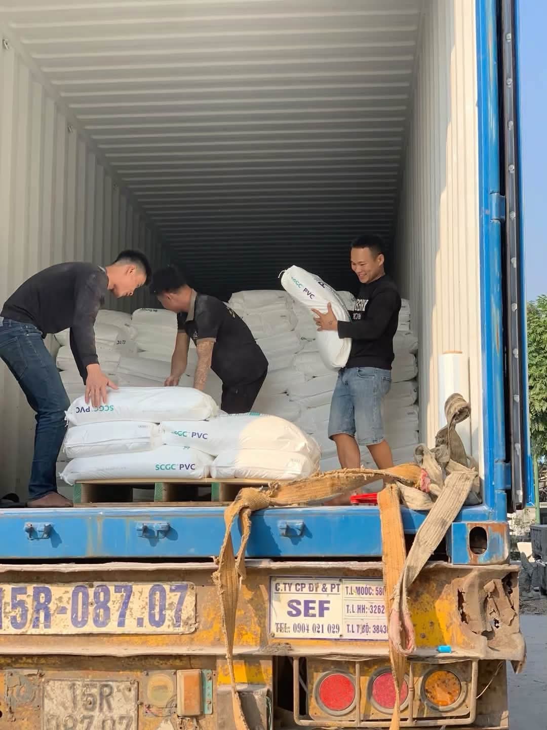 Nhân công dỡ các bao hàng lớn từ container xuống xe