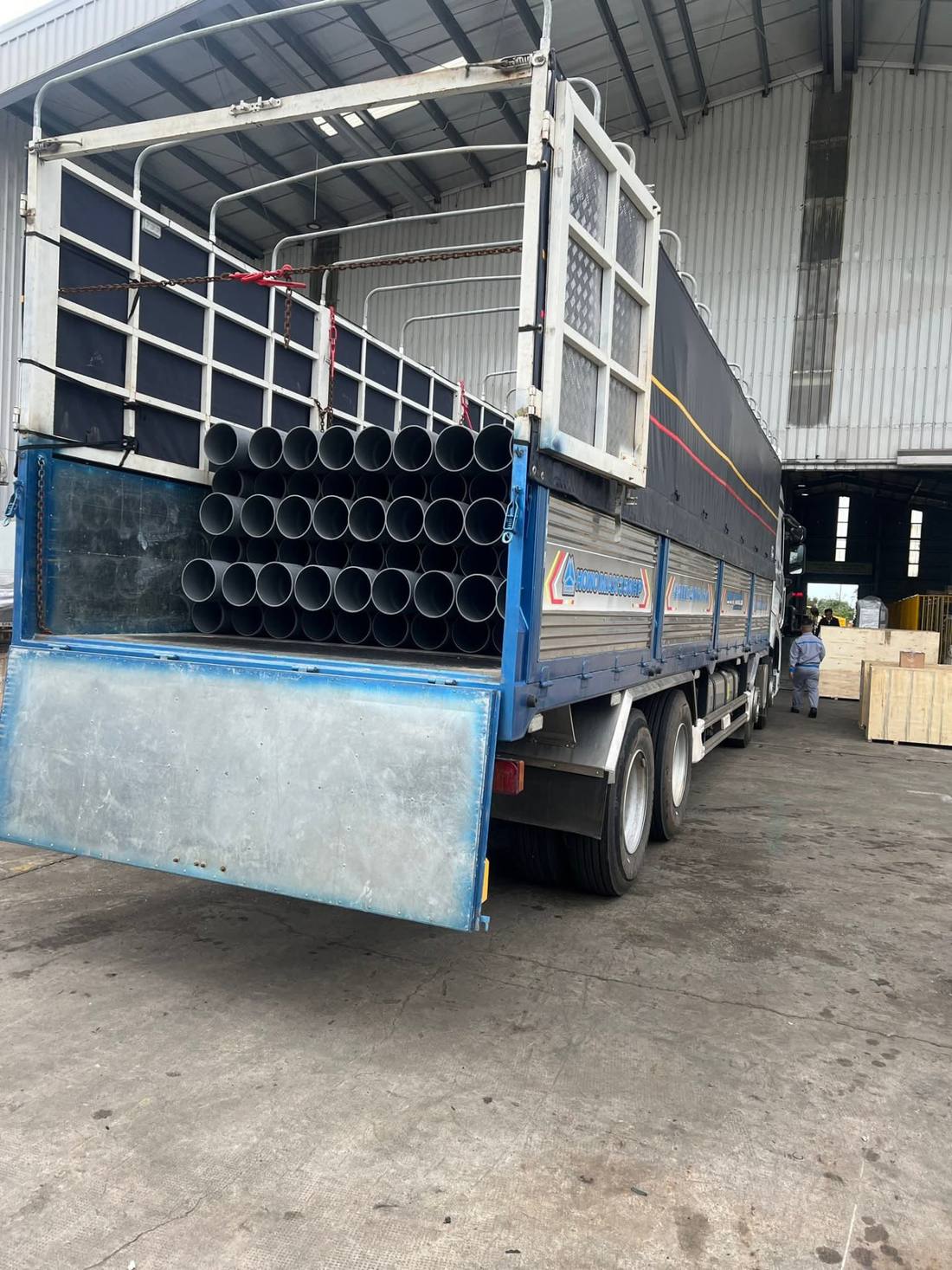 Xe tải chở đầy ống nhựa khổ lớn đang được xếp dỡ tại kho xưởng