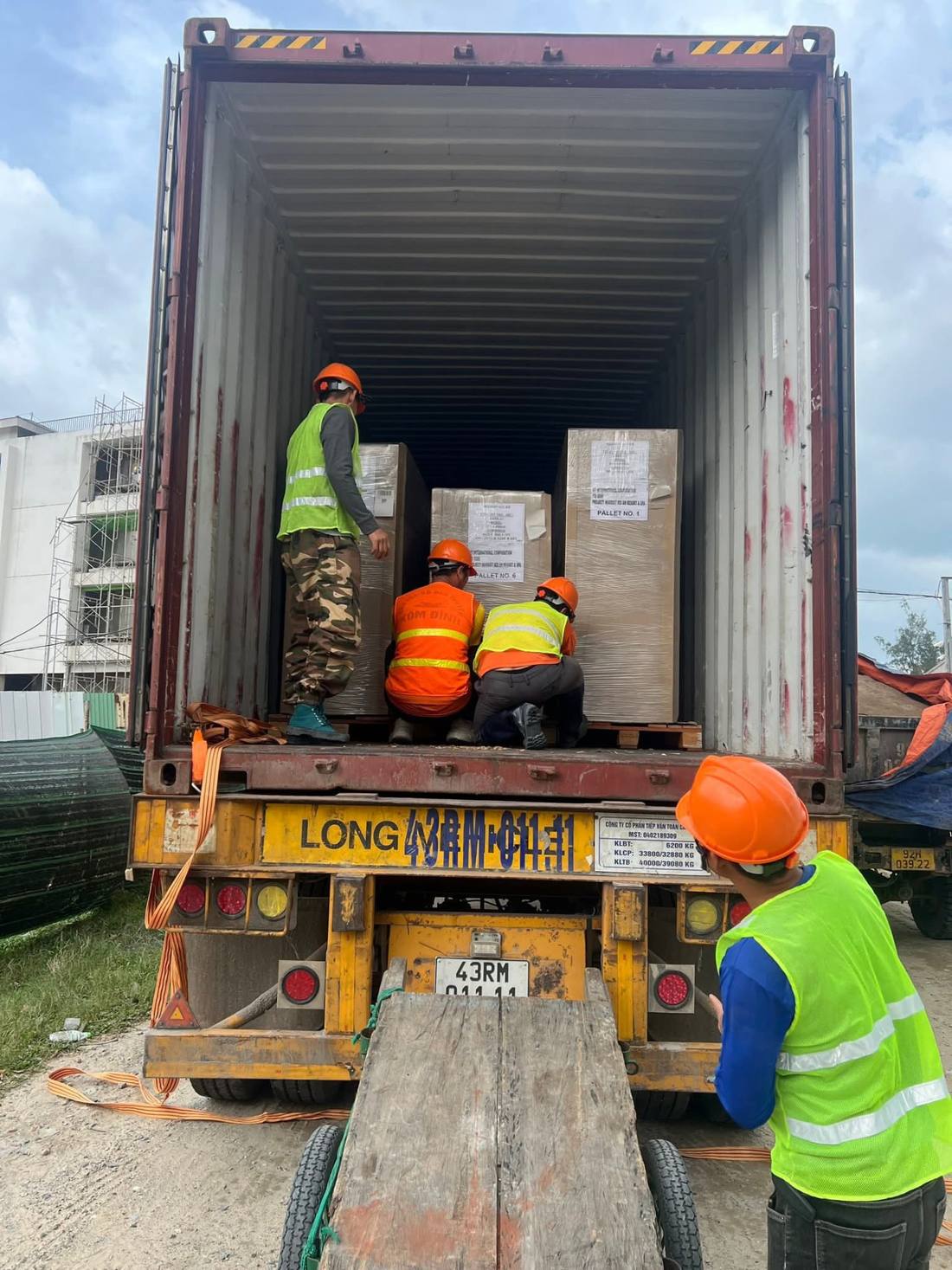 Nhân công gia cố các kiện hàng bọc màng co trong container trên rơ-moóc