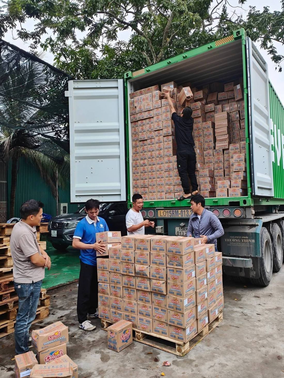 Nhân công dỡ thùng carton hàng tiêu dùng từ container xếp lên pallet